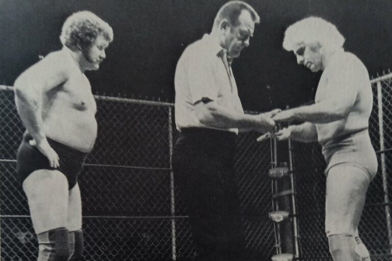 ¡Gene Kiniski como réferi epecial revisando a Ric Flair antes de su lucha contra Harley Race por el Campeonato Mundia de Peso Completo NWA dentro de la jaula de acero en Starrcade '83