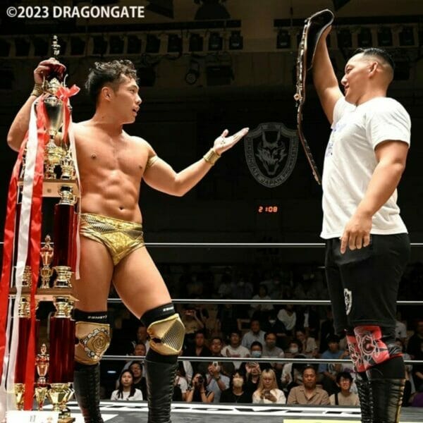 Dos luchadores con trofeos en el evento "Dangerous Gate 2023" de Dragon Gate, con Kikuta vs Minoura.