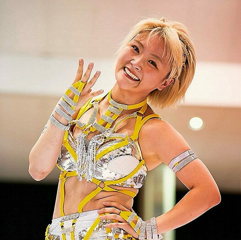 Una chica con un traje plateado y amarillo posa para la cámara en "5*Star Grand Prix 2023" Día 3.