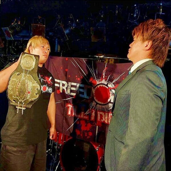 Dos hombres sosteniendo un cinturón de lucha libre en el evento "Yokohama Rush 2023" de Freedoms, que muestra la pelea entre Hirata y Sugiura.
