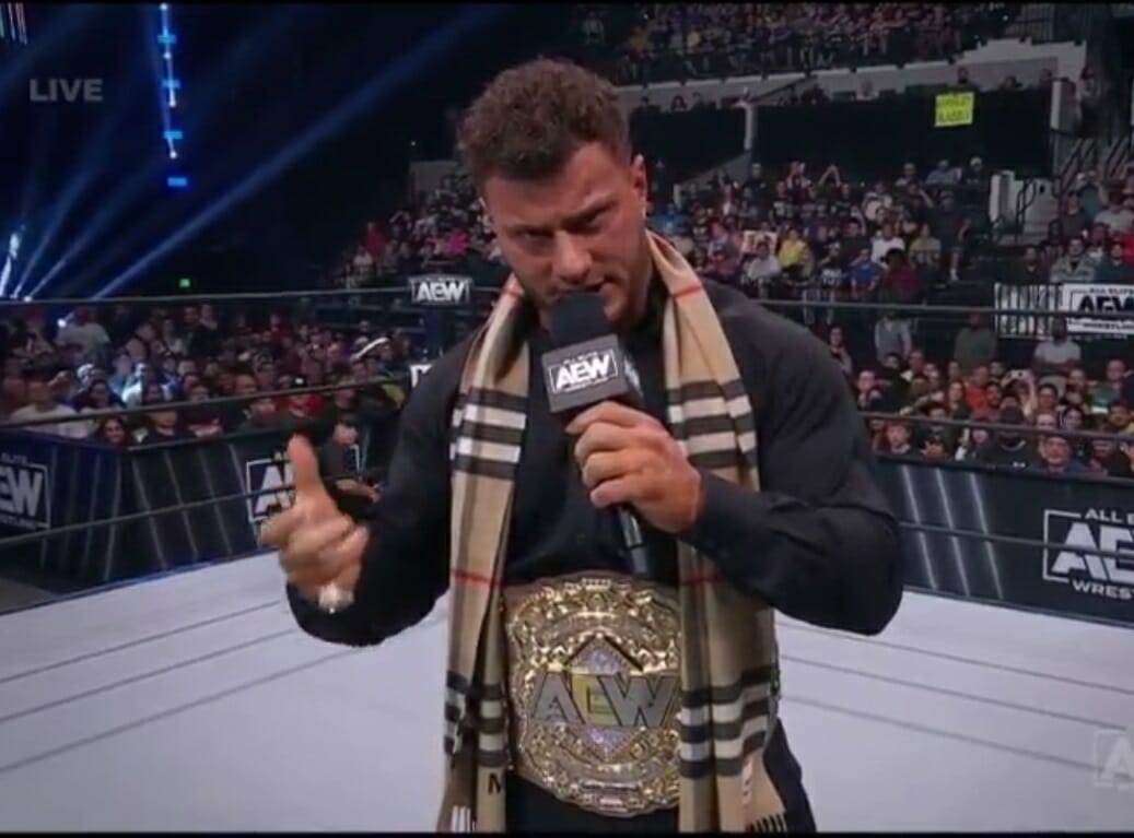 Un luchador sosteniendo un micrófono frente a una multitud en AEW DYNAMITE 2 de agosto de 2023.