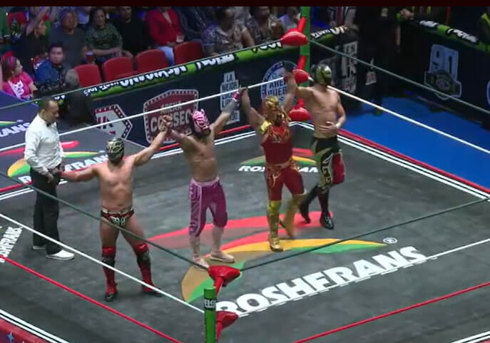 Un grupo de luchadores, entre ellos Titán y Soberano Jr., en un ring de lucha libre.
