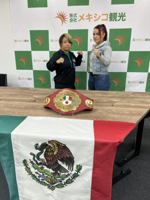 Dos siluetas paradas frente a una bandera mexicana.