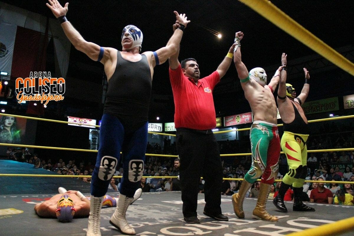 Superluchas - Un grupo de luchadores con las manos levantadas en el aire, mostrando Leyendas en acción.