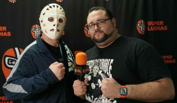 Superluchas - Un hombre con una máscara de hockey posa con un micrófono.