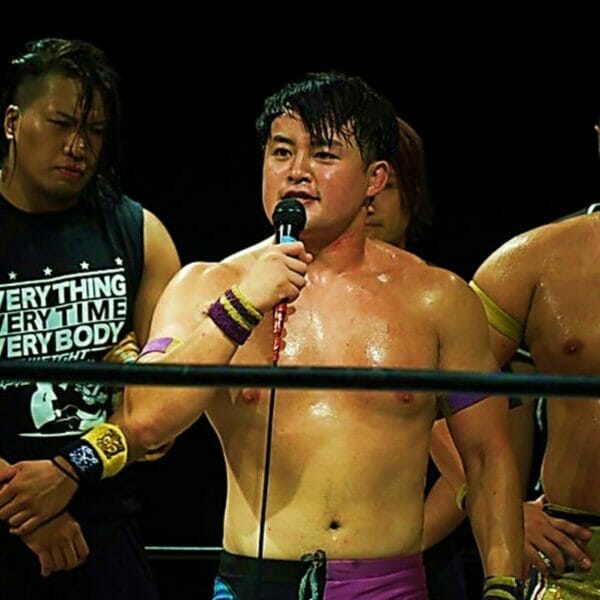 Superluchas - Un grupo de luchadores con micrófonos frente a ellos en BJW.