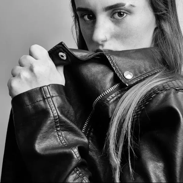 Superluchas - Una fotografía en blanco y negro de una mujer con una chaqueta de cuero.