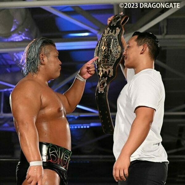 Superluchas - Dos luchadores de Dragon Gate parados uno al lado del otro sosteniendo un cinturón.