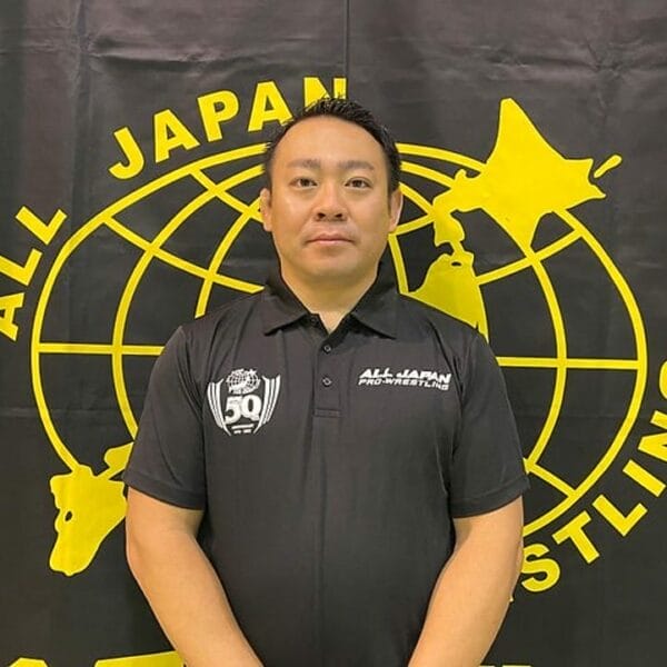 Superluchas - El sobrino de Giant Baba hace su debut como árbitro, parándose orgulloso frente a una pancarta de lucha libre totalmente japonesa.