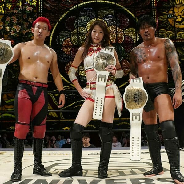 Superluchas - Tres luchadores asiáticos posando con sus cinturones de DDT: Eruption retiene el campeonato.