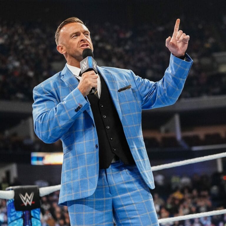 Superluchas - "Nick Aldis es perfecto para la WWE", dice Mickie James, un hombre con traje azul hablando por un micrófono.