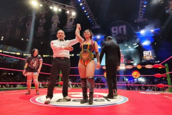 Superluchas - La Catalina, la nueva Campeona Universal de Amazonas, se encuentra con confianza junto a un hombre en un ring de lucha libre.