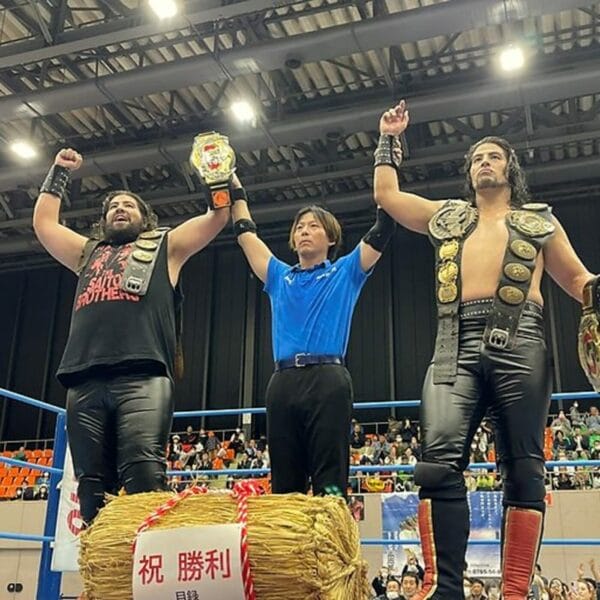 Superluchas - Tres luchadores parados encima de un fardo de heno en AJPW.
