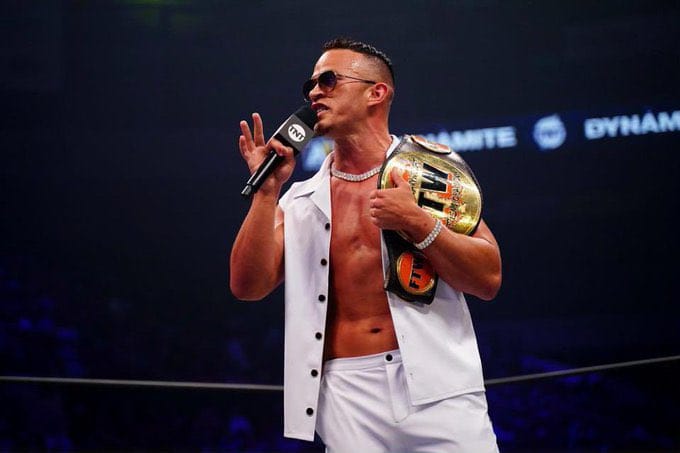 Superluchas - Ricky Starks, un luchador con camisa blanca, sostiene un micrófono.