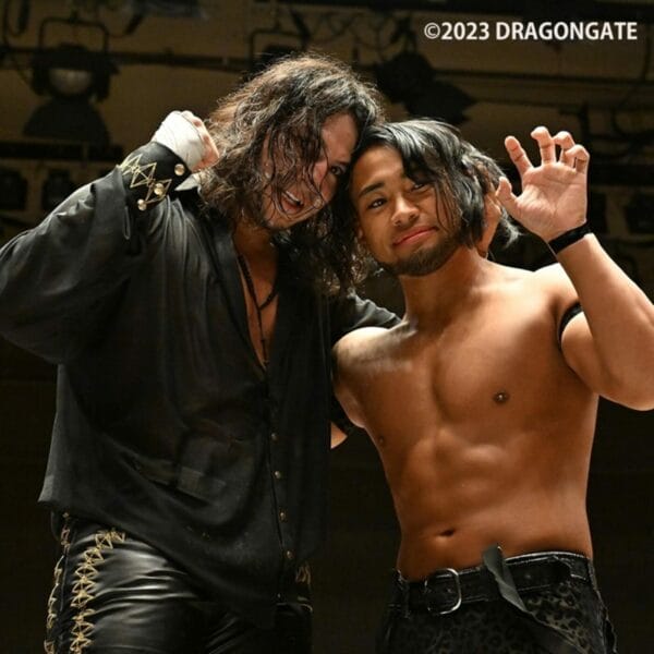 Superluchas - Dos luchadores en Dragon Gate parados uno al lado del otro.