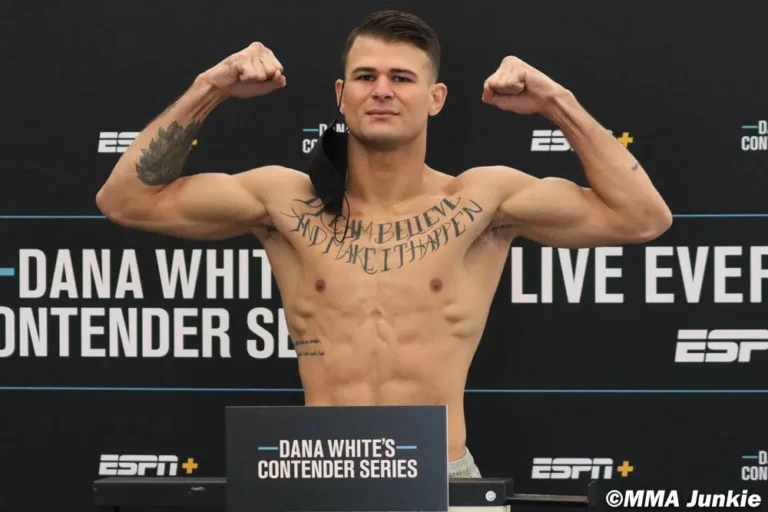 Superluchas - Un hombre con tatuajes posando en una conferencia de prensa después de UFC 295.