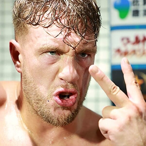 Superluchas - El luchador de NJPW, David Finlay, hace un signo de la paz con las manos durante un ataque a Ospreay y Moxley.