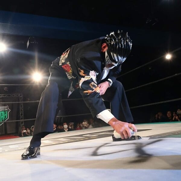 Superluchas - Luchador de NOAH con traje negro arrodillado en el ring, Reaparece Great Muta.