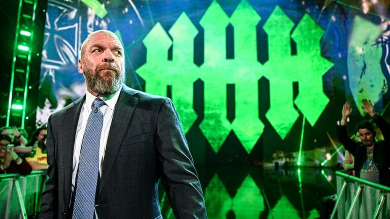 Superluchas - Triple H, un hombre de traje, parado frente a una multitud.