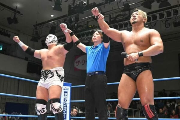 Superluchas - Dos luchadores con sus manos levantadas en el aire. (AJPW: Inician dos competencias)