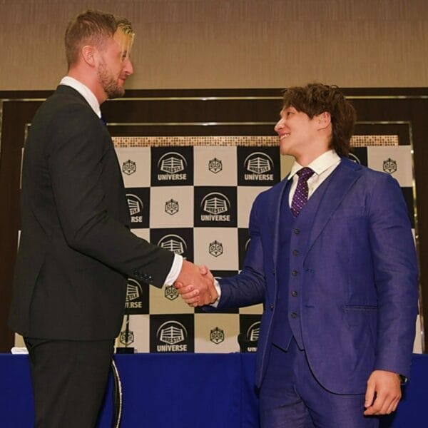 Superluchas - Dos hombres de traje se dan la mano en la conferencia de prensa "Ultimate Party 2023".