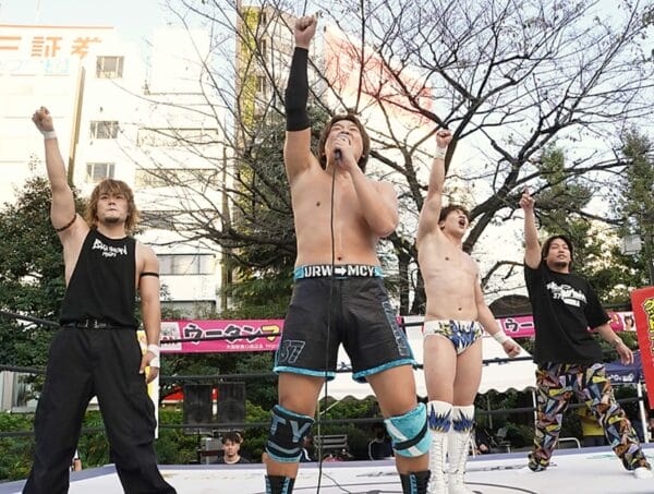Superluchas - Un grupo de luchadores interpretando DDT en un escenario frente a una multitud.