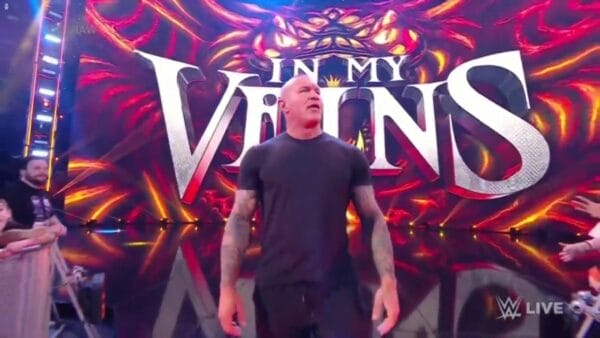 Superluchas - Un hombre parado frente a una pantalla grande que muestra las palabras "en mis venas" junto con lo más destacado y lo más bajo de WWE RAW el 27 de noviembre de 2023.