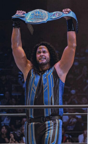 Superluchas - Hikuleo revela la verdad sobre su posible incorporación a la WWE mientras sostiene un cinturón azul y negro.