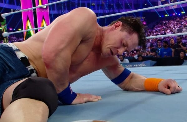 Superluchas - Un luchador, John Cena, tirado en el suelo en un ring de lucha libre después de ser derrotado por Solo Sikoa.