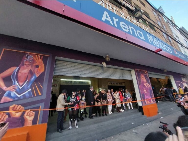 Superluchas - Un grupo de personas revela un mural frente a un edificio.