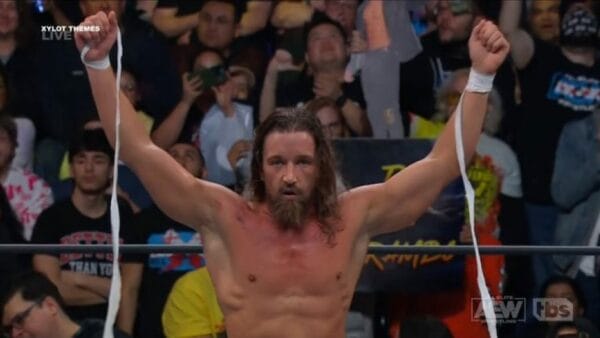 Superluchas - Un luchador triunfante celebrando con los brazos en alto después de derrotar a su oponente mediante un movimiento astuto.