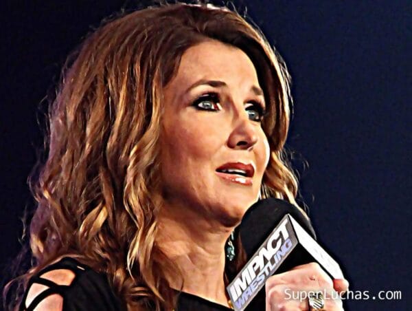 Superluchas - Dixie Carter sostiene un micrófono y habla por él detrás del escenario en RAW.