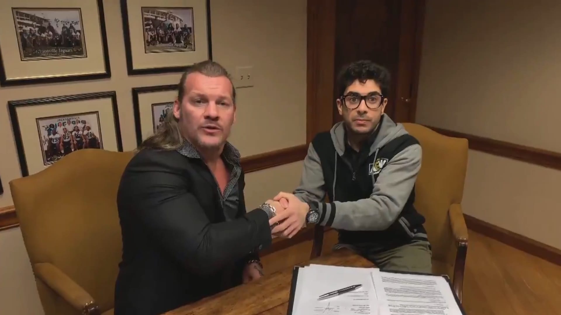 Superluchas - Dos hombres se dan la mano frente a un escritorio mientras Chris Jericho analiza los 5 años de vida de AEW.