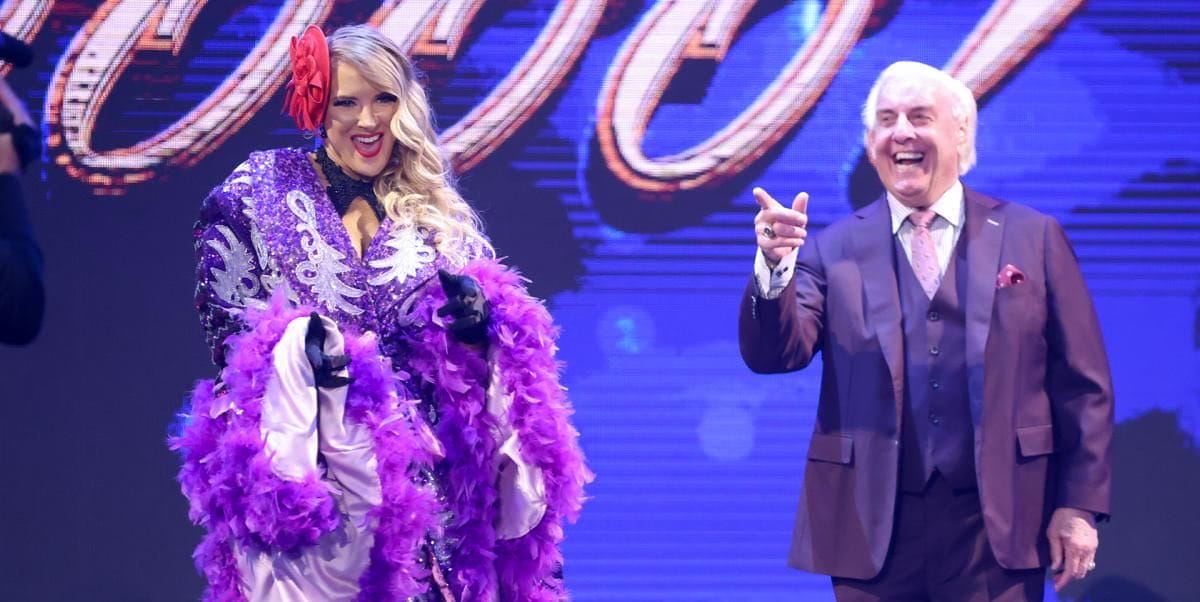 Superluchas - Un hombre con un traje morado y una mujer con un vestido morado llaman la atención de Lacey Evans durante su embarazo en la WWE.