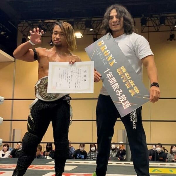 Superluchas - H.Y.O, un luchador de Dragon Gate, está junto a otro luchador que sostiene un certificado.
