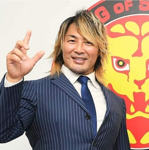 Superluchas - Un hombre de traje posa para la cámara.