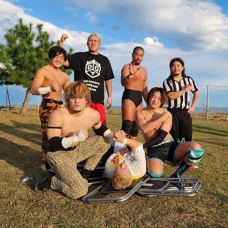 Superluchas - Un grupo de luchadores realizando movimientos de DDT mientras posan para una foto durante un emocionante evento de Lucha callejera en Fukushima.