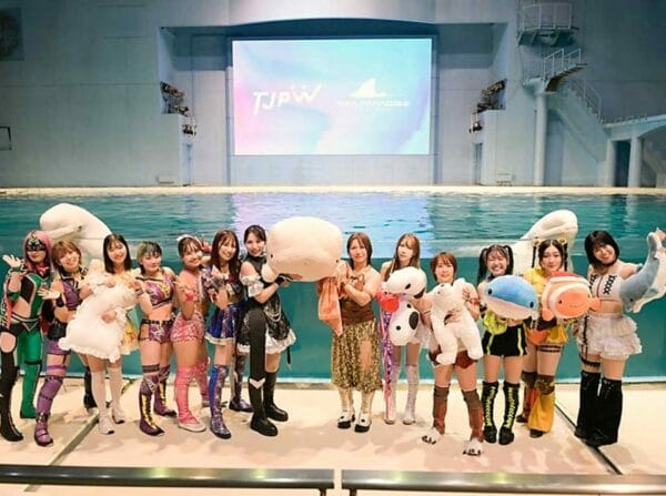 Superluchas - Luchadores de TJPW posando frente a una piscina.