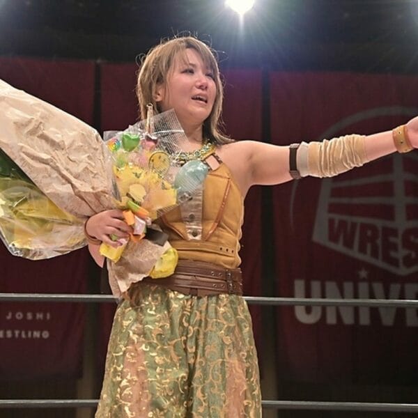 Superluchas - Una mujer con un vestido dorado sostiene un ramo de flores durante el evento "El adiós de Yuka Sakazaki" de TJPW.