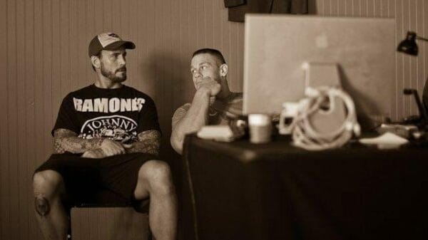 Superluchas - Rey Mysterio y Eddie Guerrero sentados frente a una computadora.