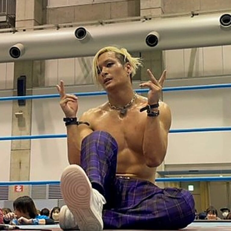 Superluchas - Un luchador está sentado en el suelo y haciendo una señal para el evento "Real World Tag League 2023" de AJPW.