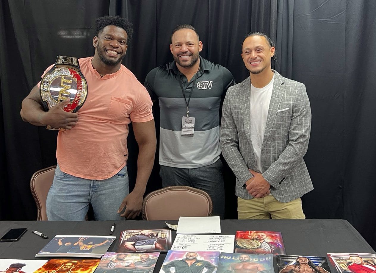 Superluchas - Tres hombres posando frente a una mesa con libros, discutiendo los nuevos emprendimientos de AEW y la renuncia de CM Punk.