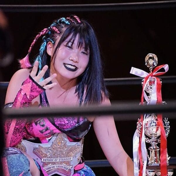 Superluchas - Una luchadora con un trofeo en la mano, que representa el torneo "New Blood West 1" de Stardom.