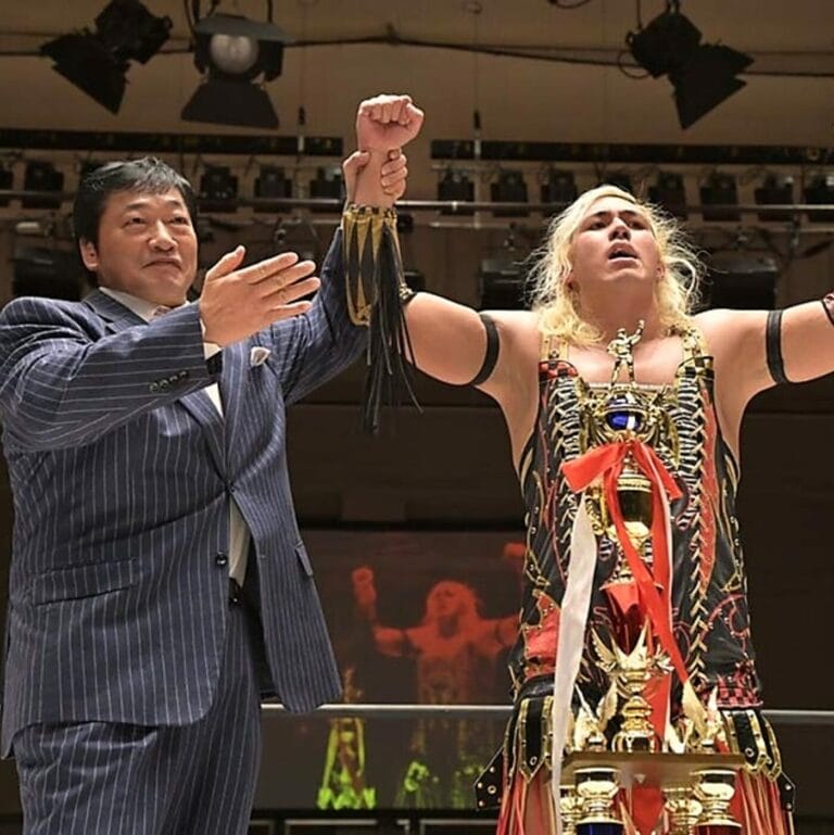 Superluchas - Un luchador, Yukio Naya, sostiene un trofeo frente a una multitud en el evento D-Ou Grand Prix 2023 organizado por DDT.