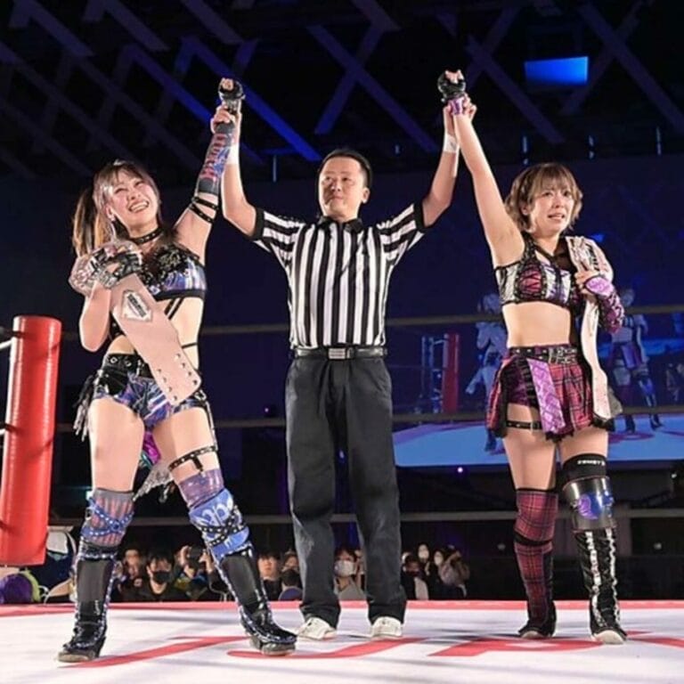 Superluchas - Tres luchadoras con las manos levantadas en el aire, celebrando su victoria en el campeonato en parejas de TJPW.