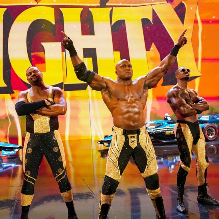 Superluchas - Los luchadores estancados, incluido Montez Ford, miembro de Street Profits, están parados en un escenario.