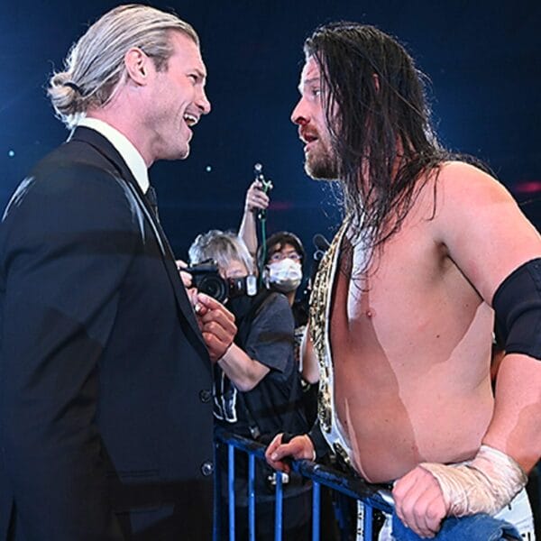 Superluchas - Dos luchadores, Dave Finlay y NJPW, entablando una conversación dentro del ring de lucha libre mientras discuten sobre el prestigioso Campeonato Global IWGP.