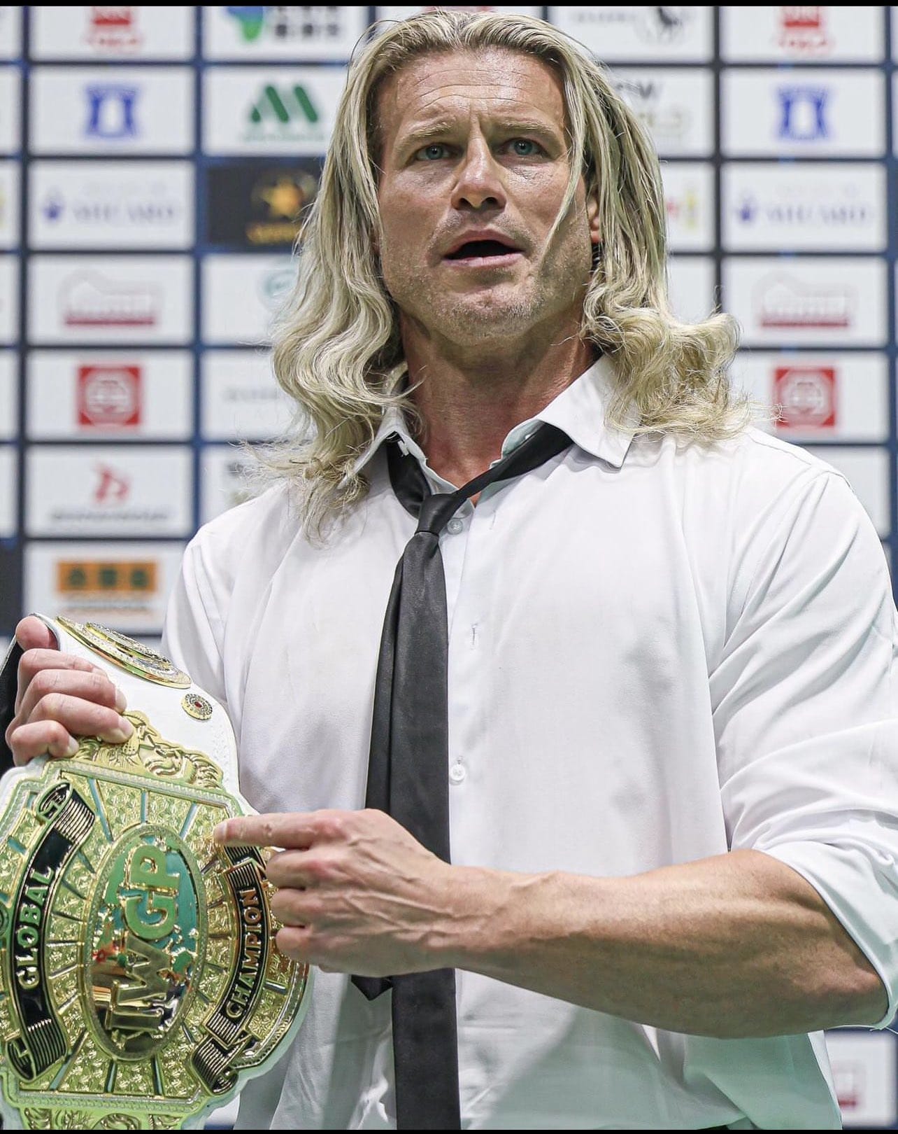 Superluchas - Dolph Ziggler sosteniendo un cinturón de lucha libre.