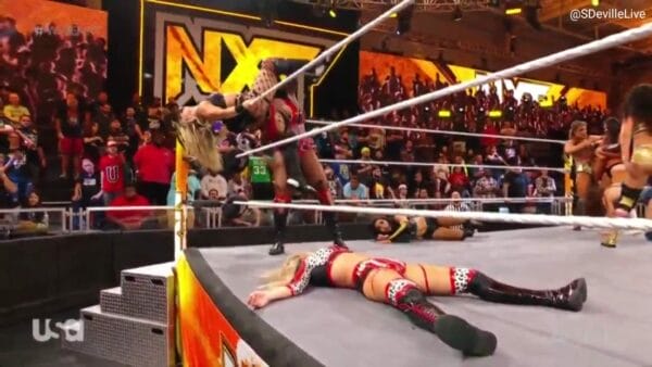 Superluchas - Una mujer mostrando sus habilidades de lucha libre en un ring de WWE NXT, observada atentamente por una multitud apasionada.