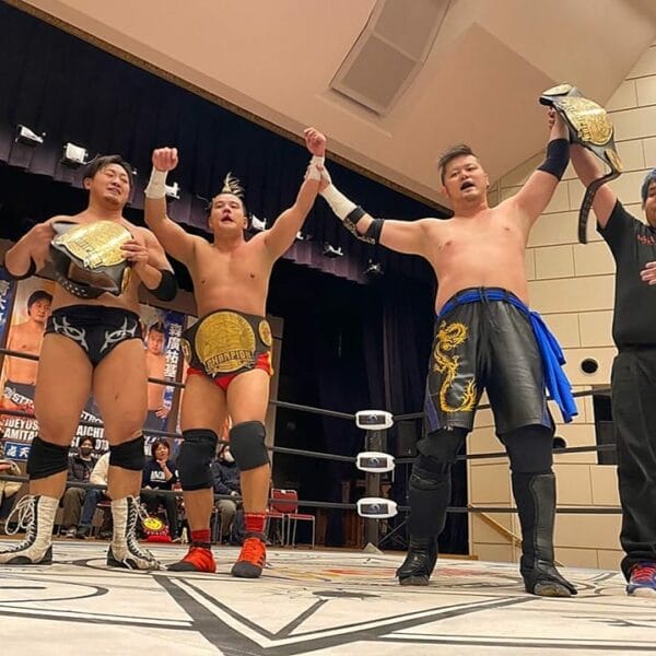 Superluchas - Un grupo de luchadores con las manos levantadas en el aire celebran su victoria en el campeonato BJW.